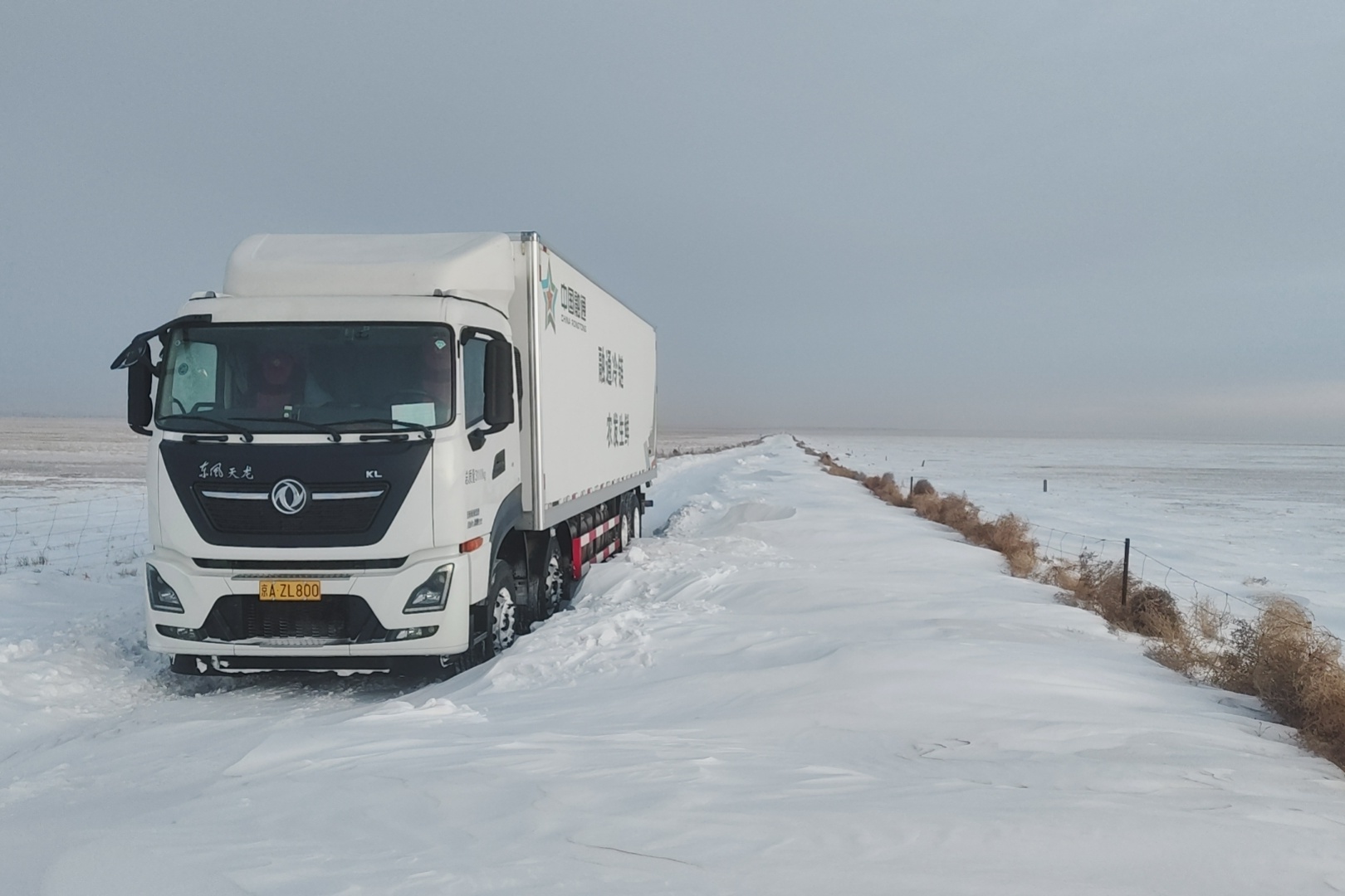 融通农发冷链运输车碾过积雪与泥泞驶向伙食单位.jpg